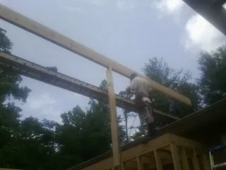 Carpenter setting a ridge beam over a new addition frame — Ice Dam Removal by Roofing Brothers in Browntown