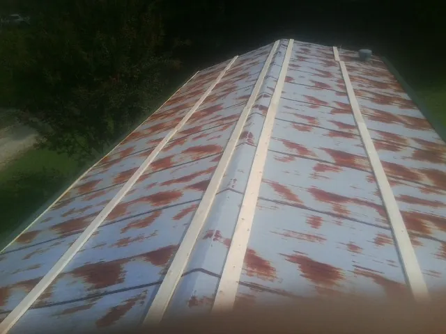Rusted metal roof panels with new wood purlins before replacement — Storm Damage Roof Repair in Browntown by Roofing Brothers